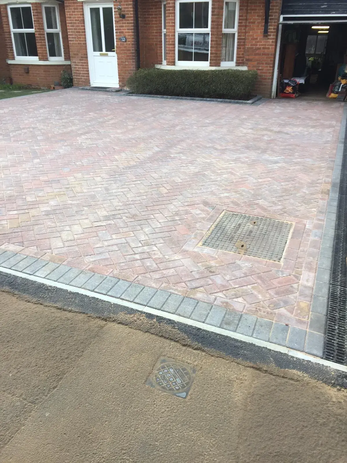 Completed driveway paving matching manhole covers seamlessly