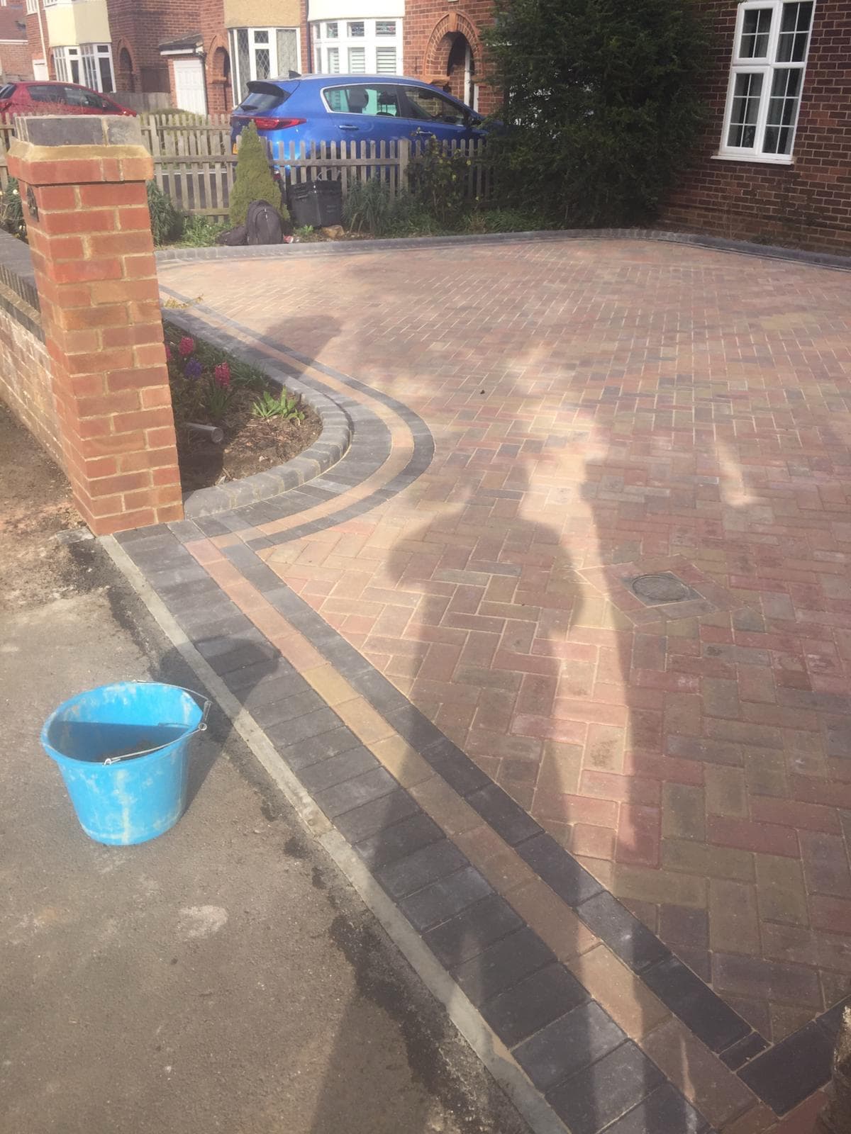 Front driveway with curved flowerbed border and block paving