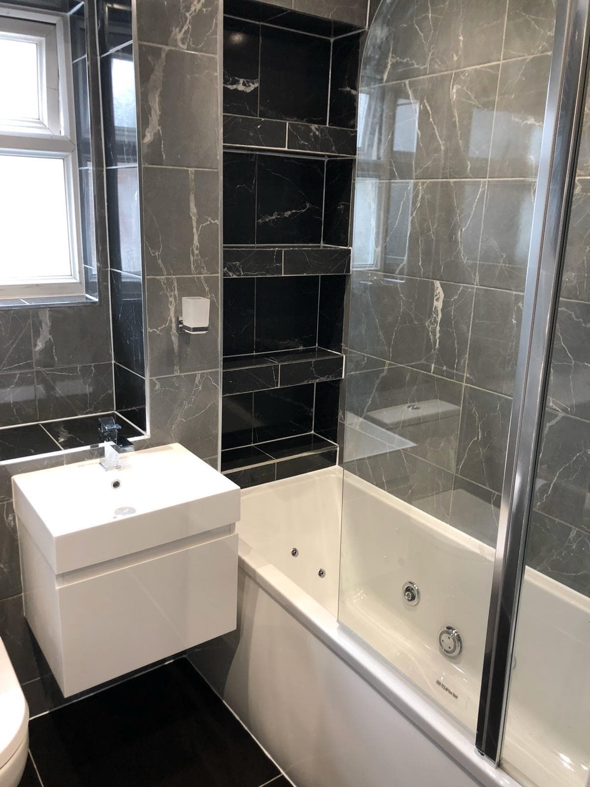 Completed bathroom with sink, tub and tiling by BBBrotherBuilding