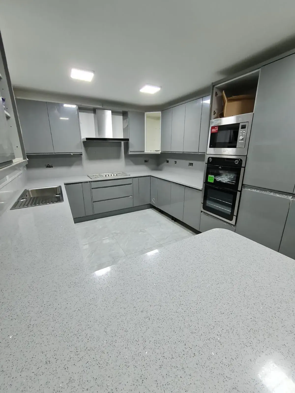 Kitchen with built-in oven, storage units, and marble worktop