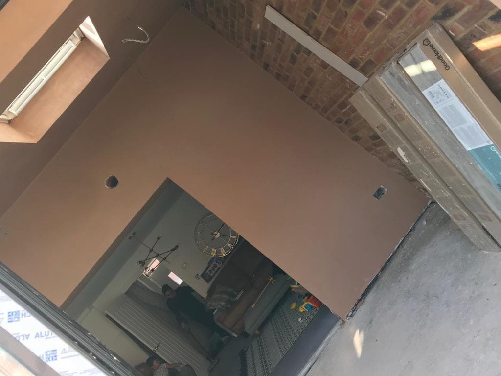 Living room with plastered walls and skylight detail by BBBrotherBuilding